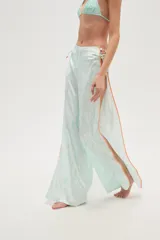 Pantalón largo de tela fluida con estampado de cebra en tonos rosa y fucsia. Tiene corte ancho y aberturas laterales con detalle de argollas.