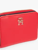 Billetera roja Tommy Hilfiger con cierre de cremallera y monograma TH metálico dorado.