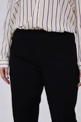 Pantalón negro cropped de calce recto, confeccionado en algodón y spandex, con bolsillos laterales y cintura media.