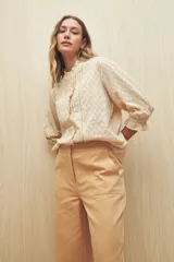 Pantalón de vestir color beige, de corte wide leg y tiro alto, con bolsillos laterales y traseros.