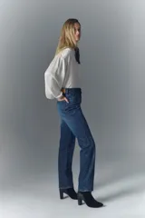 Pantalón de jean de tiro alto, denim azul rígido con lavado oscuro y apliques de brillos.
