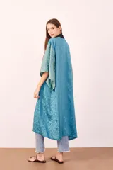 Kimono largo color celeste con estampado de textura y ribete negro.