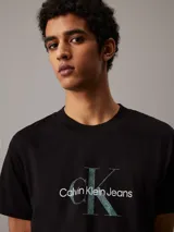 Remera negra de manga corta con cuello redondo y logo Calvin Klein Jeans estampado en el pecho con efecto brillante.