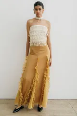 Falda larga color ocre de corte ajustado, con volados verticales en los laterales.