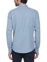 Camisa celeste de manga larga con textura waffle, cuello abotonado, bolsillo en el pecho y logo bordado.
