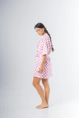 Bata kimono corta de algodón estampado con flores rojas, violetas y verdes. Tiene mangas al codo y lazo de ajuste en la cintura.