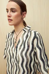 Vestido corto con estampado de rayas onduladas en blanco y azul, cuello tipo solapa y escote en V.