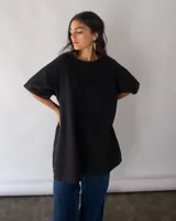 Vestido negro de denim de algodón, corte amplio en A y bolsillos laterales.