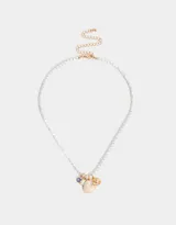 Collar corto con perlas blancas irregulares y dijes colgantes dorados: cristal amatista, rectángulo de nácar, corazón de nácar y dije circular con diseño de corazón y rayos.