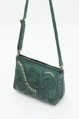 Cartera bandolera verde de cuero vacuno con bordado de flores y tachas doradas y plateadas. Tiene cierre metálico superior, forro de algodón, división interna, bolsillo y tarjetero. La correa es regulable.