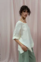 Blusa color crudo de lino, con cuello redondo y mangas 3/4 con dobladillo.