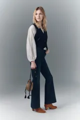 Pantalón de jean de tiro medio, calce ajustado, lavado azul oscuro, pierna levemente acampanada con ruedo ancho.