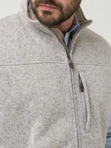 Chaleco de polar color beige con cierre frontal y cuello alto. Cuenta con tres bolsillos con cierre en el frente. Confeccionado con poliéster reciclado proveniente de botellas PET.