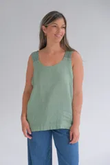 Musculosa verde con cuello redondo y sisas amplias. Presenta detalle de rayas verticales en los hombros y la espalda.