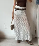 Pollera larga de encaje blanco con cintura elastizada y forro interior.