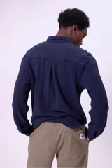 Camisa azul marino de manga larga con cuello abotonado y bolsillo en el pecho.