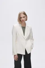 Blazer color crudo de rayon, entallado, con cuello solapa y cierre con un botón.