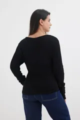 Sweater rojo de tejido de punto acanalado, con escote en V y cierre frontal con cremallera circular.