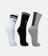 Kit de tres pares de medias deportivas Puma de caña larga. Un par color beige con dos rayas marrones horizontales en la parte superior y logo marrón en el tobillo. Un par color crema liso con logo blanco en el tobillo. Un par color marrón con una raya blanca horizontal en la parte superior y logo blanco en el tobillo.