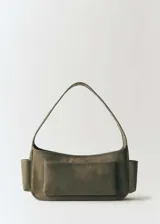 Bolso de hombro color verde oliva, de tamaño mediano, confeccionado en cuero vacuno. Presenta cierre metálico con imán, asa de hombro fija, bolsillos laterales y tachuelas decorativas.