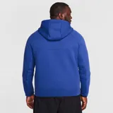 Campera deportiva Nike Tech Fleece color azul con cierre frontal, capucha y detalles en negro. Incluye logo de Nike bordado en el pecho y bolsillo con cierre en la manga izquierda.