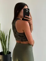 Top deportivo verde militar con estampado batik, breteles anchos y espalda deportiva.