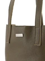 Cartera shopper de cuero graneado color verde oliva, con cierre metálico y tiradores de cuero. Interior sin forro con sobre interior con cierre.