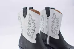 Bota texana de cuero negro con bordados en el lateral y taco bajo.