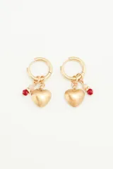 Aros dorados tipo argolla con dije de corazón en metal y piedras facetadas rojas.