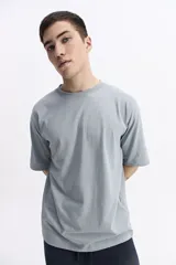 Remera lisa color beige de corte oversize, con escote redondo y mangas cortas.