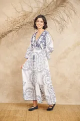 Vestido largo blanco con estampado floral azul, escote en V con cordones y mangas 3/4 abullonadas.