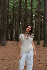 Chaleco color crudo tejido a mano en hilado 100% baby alpaca, con cuello tipo bote, hombros anchos, puntos calados en frente y espalda, y tajos laterales en el bajo.