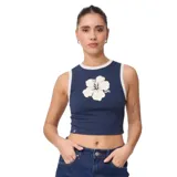 Musculosa corta azul con cuello y sisas con ribete blanco, y estampado de flor blanca en el pecho.