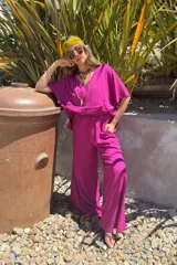 Conjunto fucsia compuesto por un remerón de mangas cortas y un pantalón palazzo de lino.