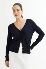 Cardigan azul marino de tejido de punto fino, con escote en V y cierre frontal con botones dorados.