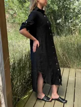 Vestido camisero largo de lino blanco, con corte en la cintura, abertura lateral y botones de nácar.