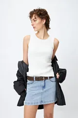 Musculosa de punto color beige, con textura acanalada y detalle de trenzado lateral ajustable.