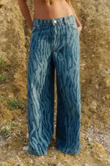 Pantalón de jean tiro medio, corte oversize y pierna ancha, con estampado láser acebrado tipo cebra.