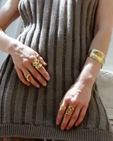 Brazalete rígido plateado con textura irregular.