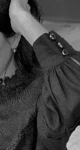 Blusa negra de lino con cuello Galón estructurado y mangas largas con puños abotonados.