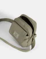 Bandolera verde militar de tela deportiva con bolsillo frontal con solapa, correa regulable, cierre superior y tag frontal con la inscripción "No Bad Vibes Allowed".