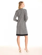 Vestido de tejido de punto marca Nina Leonard, con diseño Twofold que simula un conjunto de vestido negro liso y cárdigan largo con estampado geométrico blanco y negro. Presenta escote redondo y manga larga de corte recto.