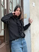 Camisa negra de lana merino con volados frontales y cierre con botones.