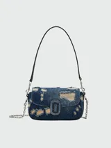Bolso de hombro Marc Jacobs modelo The Rip and Repair Denim Clover, confeccionado en denim azul con detalles desgastados y apliques.