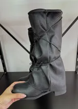 Botas de caña media color negro, de cuero vegano, con ajuste de cordones cruzados en la parte delantera.