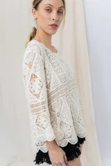 Blusa tejida calada color crudo, con diseño geométrico y motivos florales, escote redondeado y mangas 3/4 con leve vuelo.