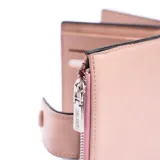 Billetera pequeña color rosa pálido con cierre de broche a presión y compartimento con cierre de cremallera.