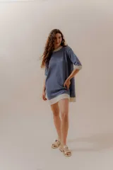 Vestido corto azul denim tejido en punto, con cuello redondo y mangas cortas con terminaciones en color crema.