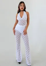 Catsuit blanco de encaje con escote halter profundo en V y pantalón acampanado.