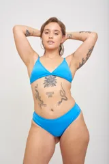 Conjunto de bikini azul con corpiño triangular con breteles regulables y copas desmontables, y bombacha clásica con argollas en los laterales.